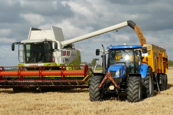 blue-tractor-next-to-white-farm-vehicle-at-daytime-163752